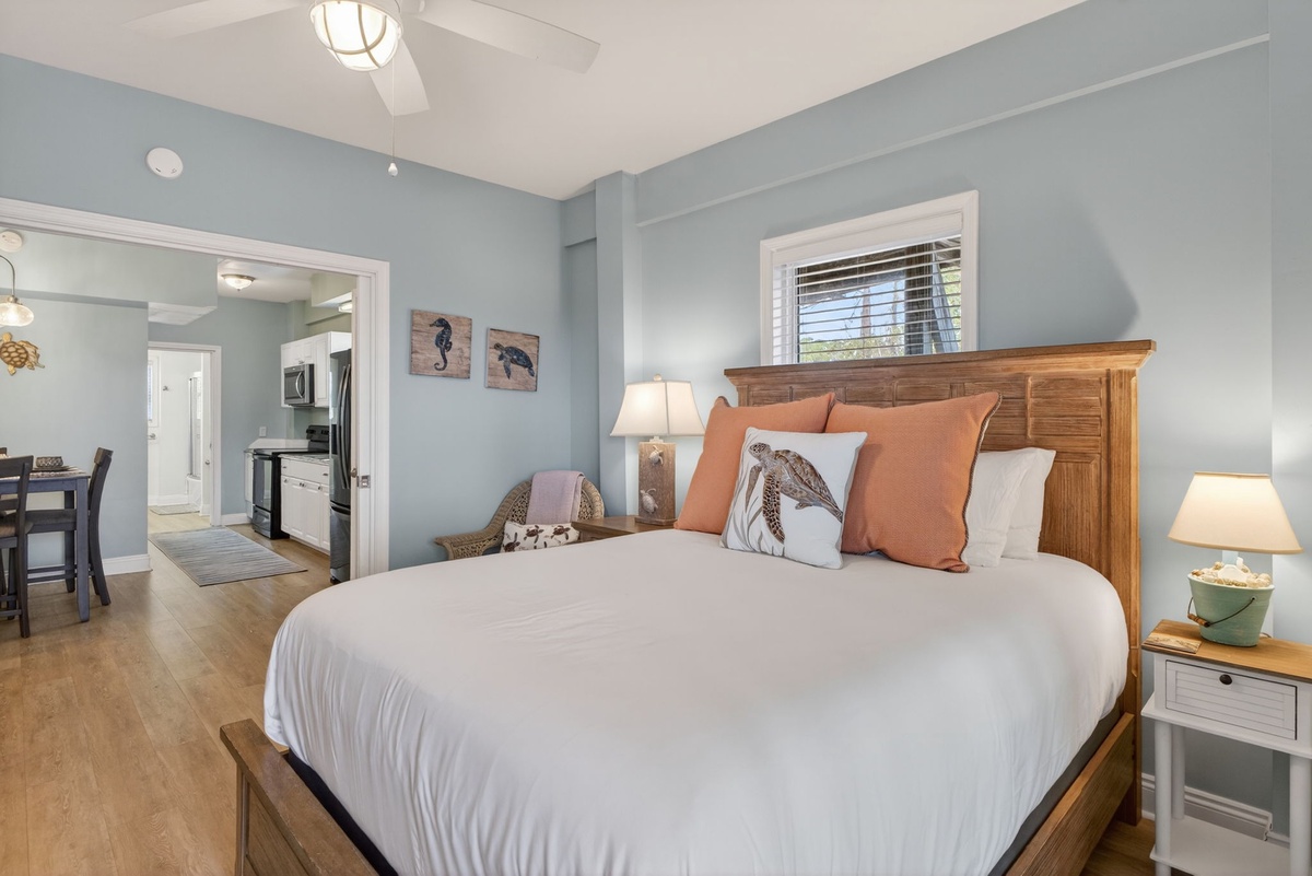 Drift into restful sleep in your coastal-themed bedroom, where soft blue walls and warm wood tones create perfect seaside tranquility.