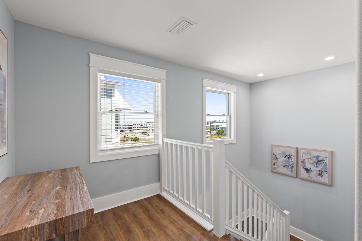 Bright upper landing space with soft natural light, warm wood floors, and peaceful views that make your stay feel fresh and welcoming.