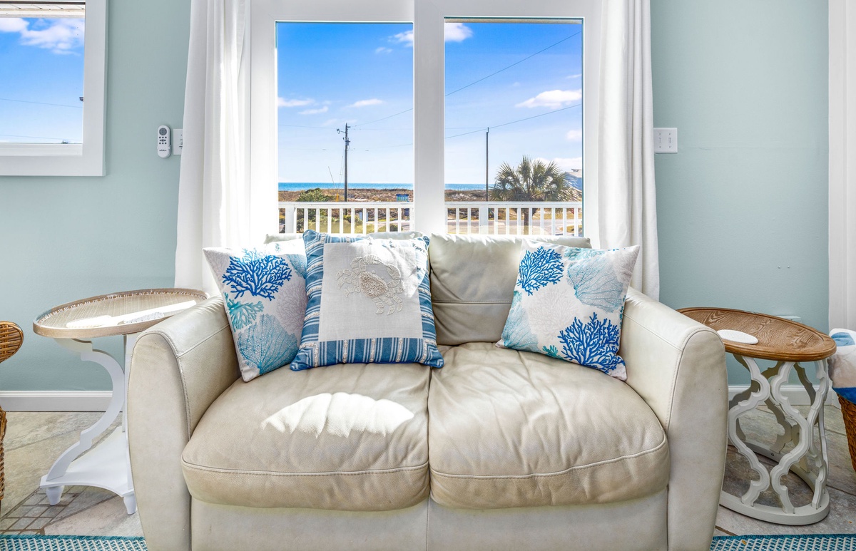 Sink into this coastal haven with ocean-themed pillows while you gaze at stunning sea views through your window.