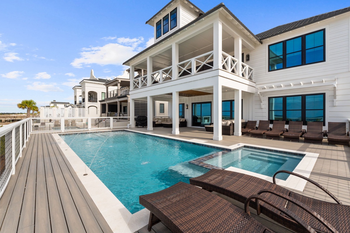 Stunning coastal property featuring luxury pool deck with oceanfront balconies and elegant architecture.