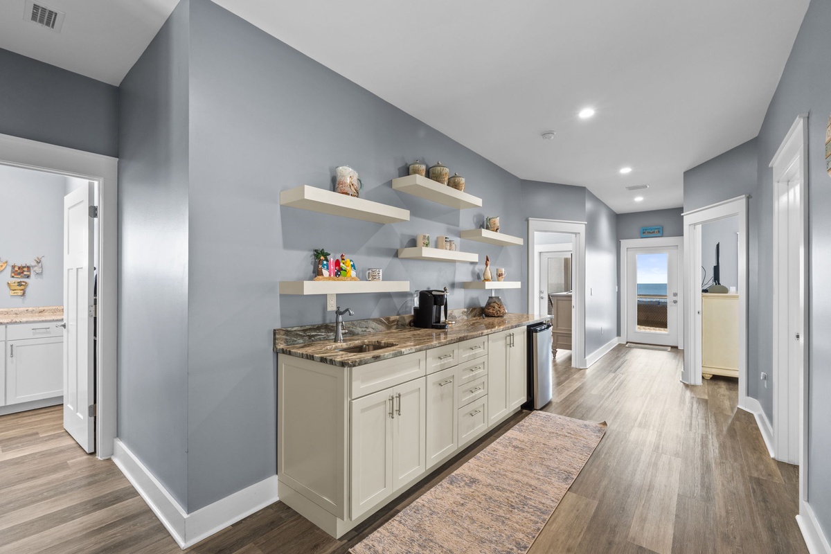 Your sleek butler's pantry features granite counters, floating shelves, and modern appliances for effortless meal prep.