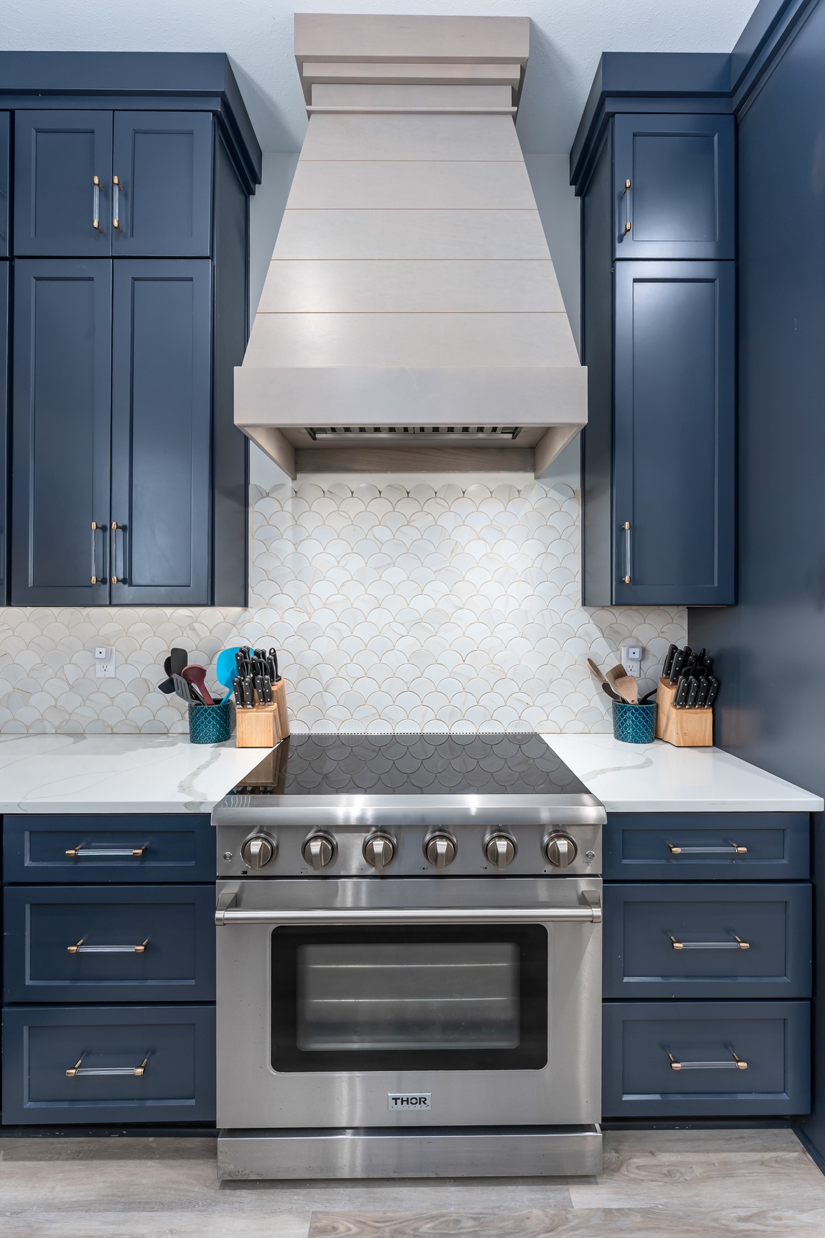 Your culinary dreams come alive in this stunning kitchen, where rich navy cabinets and gleaming appliances create the perfect space for memorable meals.