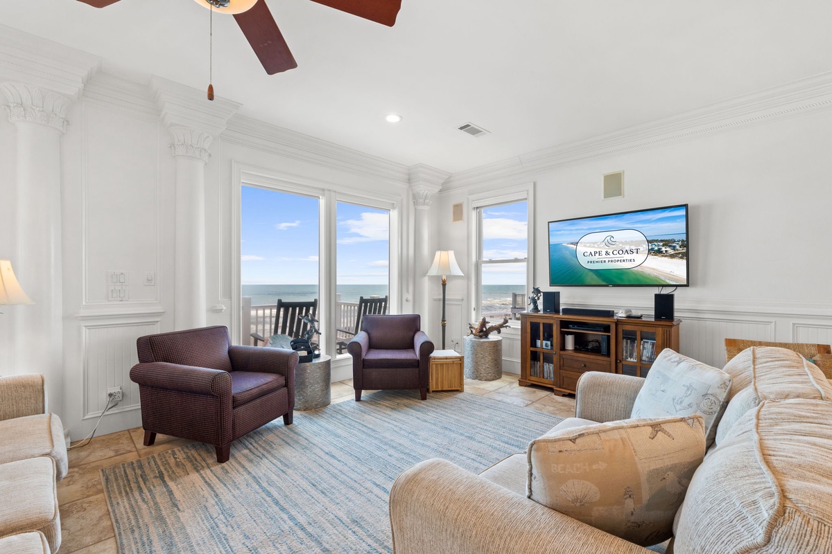 Unwind in your spacious living room where panoramic ocean views through wall-to-wall windows create a serene backdrop for relaxation, entertainment, and making vacation memories together.