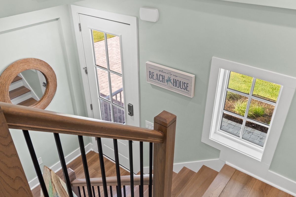 A welcoming entryway with coastal charm sets the tone for your beach house stay. Soft sage walls and warm wood tones create a soothing retreat the moment you arrive.