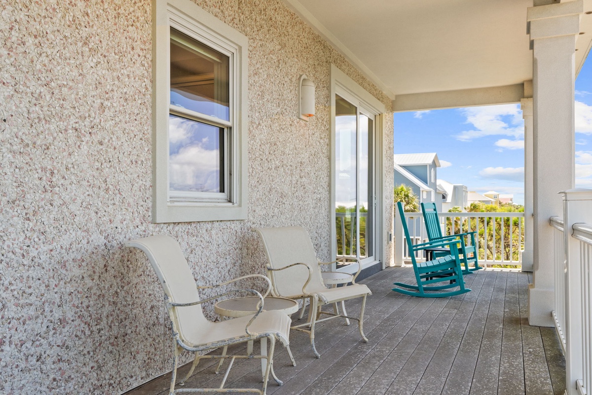 Settle into your private porch with vintage rockers and breezy coastal views—your perfect spot to sip morning coffee or watch the day unwind in peaceful comfort.