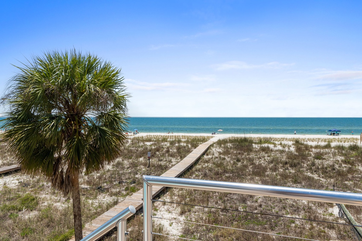 Private boardwalk leads across soft dunes to pristine white sand and sparkling turquoise waters—your personal pathway to paradise awaits.