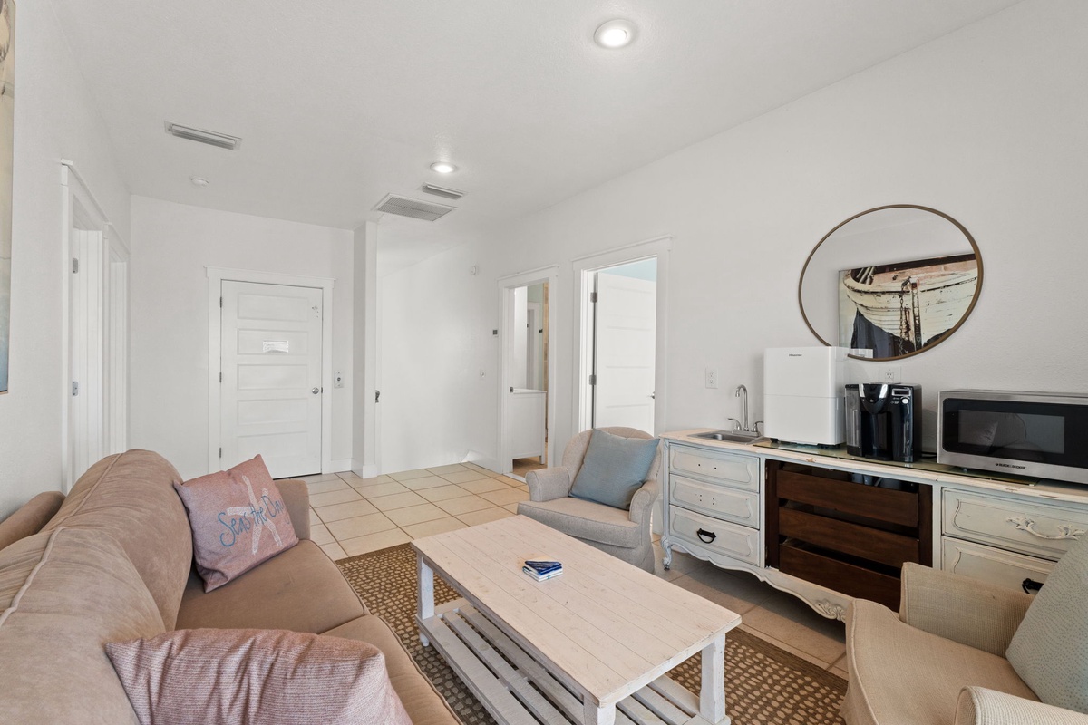 Your cozy living room features comfortable seating, nautical décor, and a convenient kitchenette area—perfect for relaxing after a day of adventure.