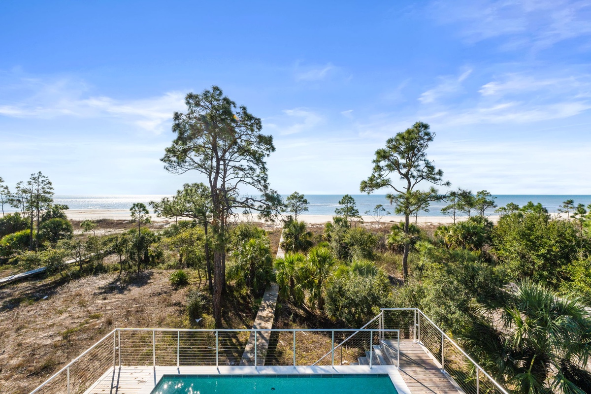 Elevated view showcasing the property's beachfront location with natural landscape and ocean access.