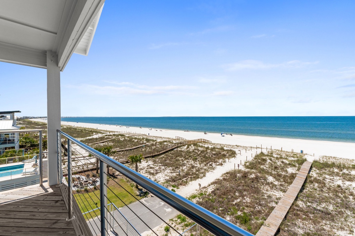 Expansive Gulf Coast views with direct beach access via wooden boardwalk. Property features private balcony overlooking white sand beaches and turquoise waters.