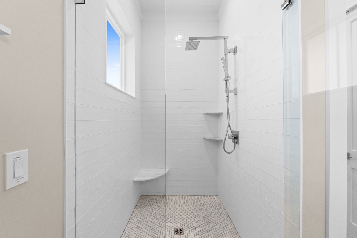 Rinse away the day in your bright, modern walk-in shower with dual fixtures and a handy built-in seat—pure relaxation awaits.