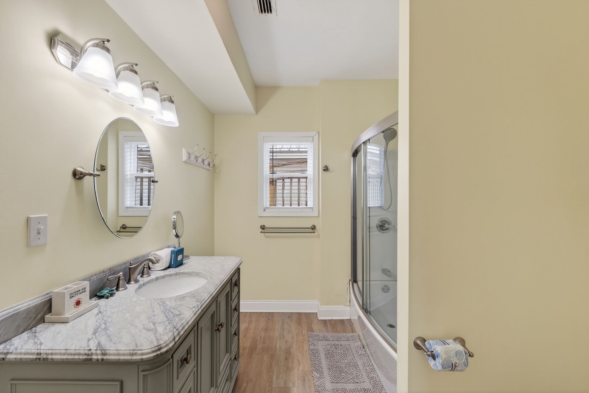 Step into your elegant bathroom with marble countertops, modern fixtures, and soothing natural light filtering through the window.