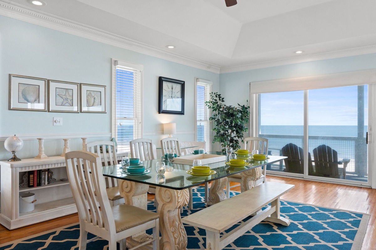 Savor meals with stunning ocean views through floor-to-ceiling windows while gentle sea breezes fill this elegant coastal dining space.