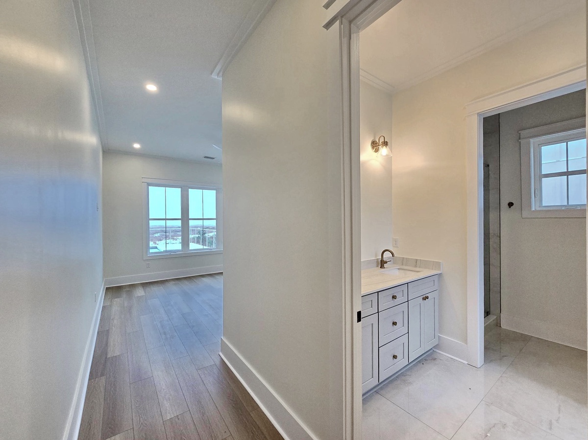 Your private bathroom features elegant white cabinetry and marble countertops, creating a spa-like retreat for your stay.