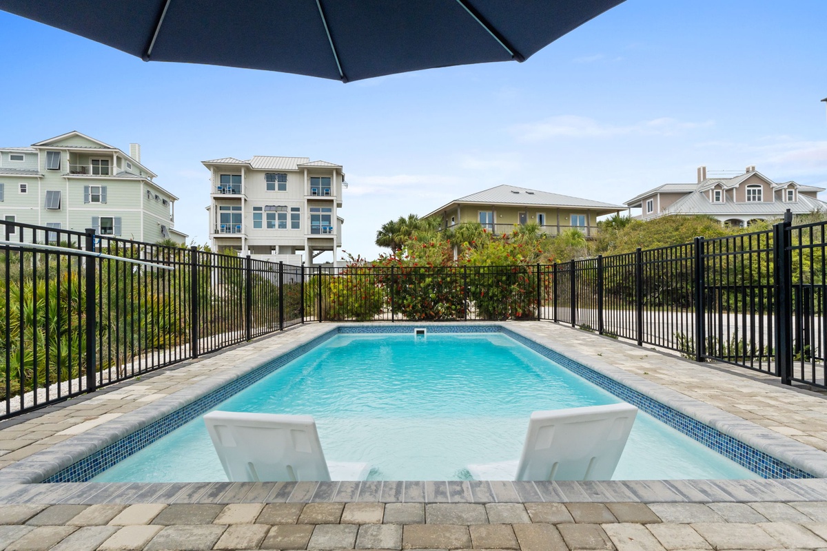 Dive into your private oasis with crystal-clear waters, poolside loungers, and coastal homes as your backdrop.