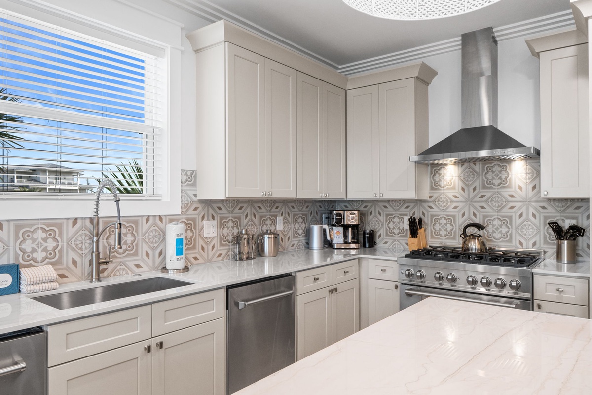 A bright, fully-equipped kitchen with elegant tile backsplash and modern appliances awaits your culinary adventures.