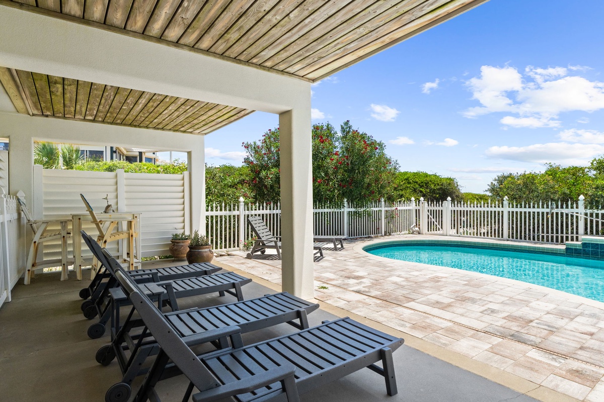 Unwind on your private loungers under the pergola, steps from the sparkling pool. The covered seating area offers shade while you soak up the tropical surroundings and sunny skies.
