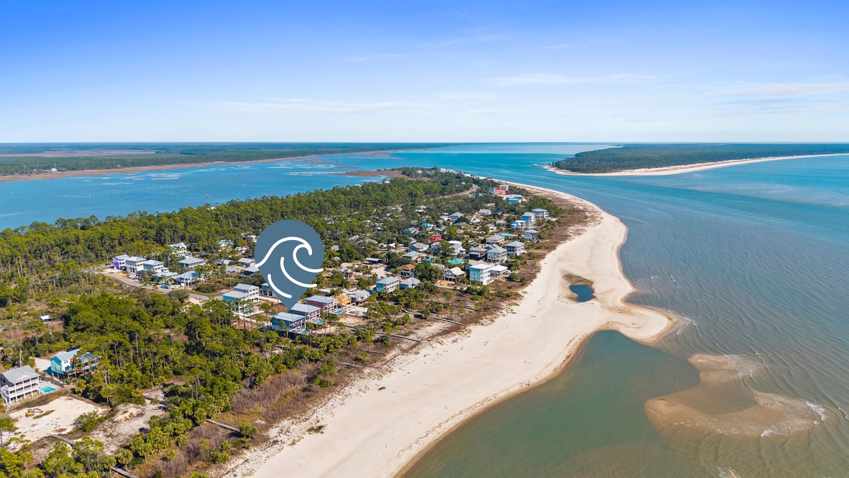 Aerial view captures a pristine coastal peninsula surrounded by turquoise waters and pristine sandy beaches.
