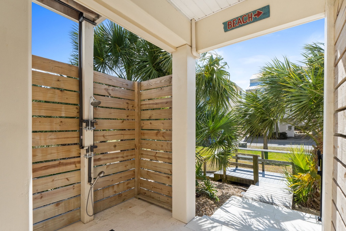 Rinse off the saltwater in your private outdoor shower surrounded by tropical palms, then follow the beach sign to paradise.