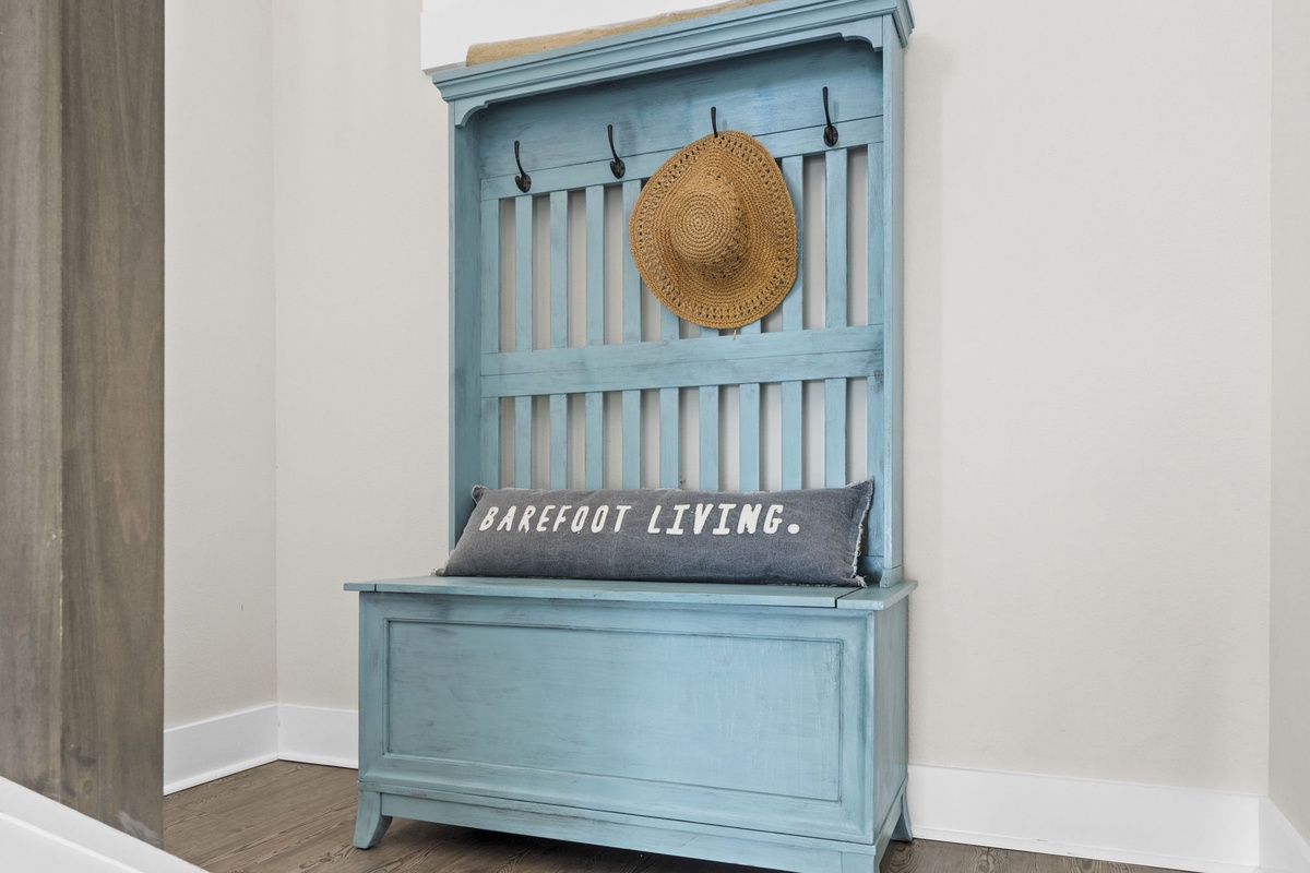 Your entryway features charming coastal storage with hooks for beach hats and a cozy bench for settling in after sandy adventures.