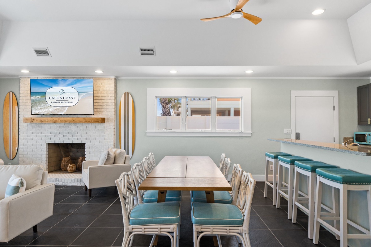 This coastal-inspired communal lounge invites you to gather with friends around the dining table or relax by the fireplace, with surfboard décor and a bar for socializing.