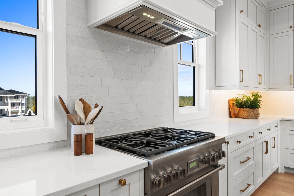 Your gourmet kitchen awaits with professional-grade appliances and elegant white cabinetry, perfectly designed for memorable meal preparations during your stay.