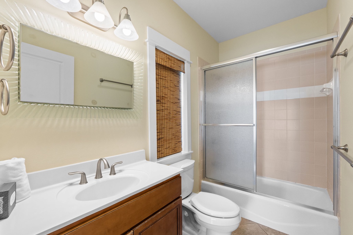 Step into your bright, well-appointed bathroom featuring a glass-enclosed shower, elegant vanity, and thoughtful touches for your comfort.