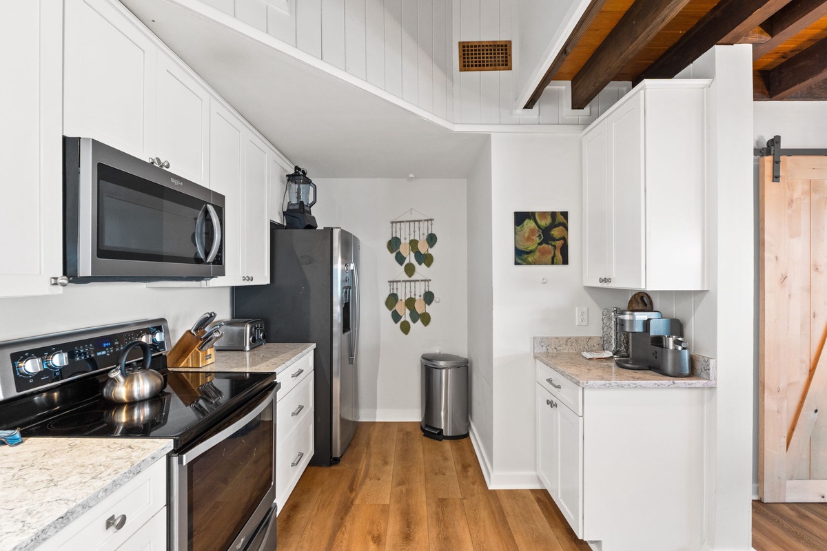 Your fully equipped kitchen features sleek stainless-steel appliances, ample counter space, and warm wood floors—perfect for whipping up a delicious meal after a day of adventure.