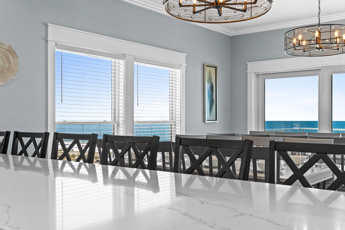 Gather around this spacious dining table and take in breathtaking sea views through expansive windows. The elegant coastal design and natural light create your perfect setting for memorable meals together.