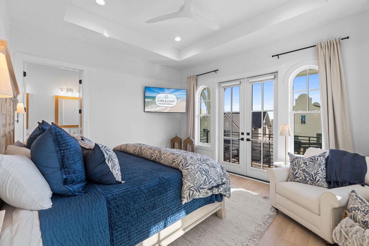 Drift to sleep in your elegant coastal bedroom, where tray ceilings and french doors frame sunny balcony views.