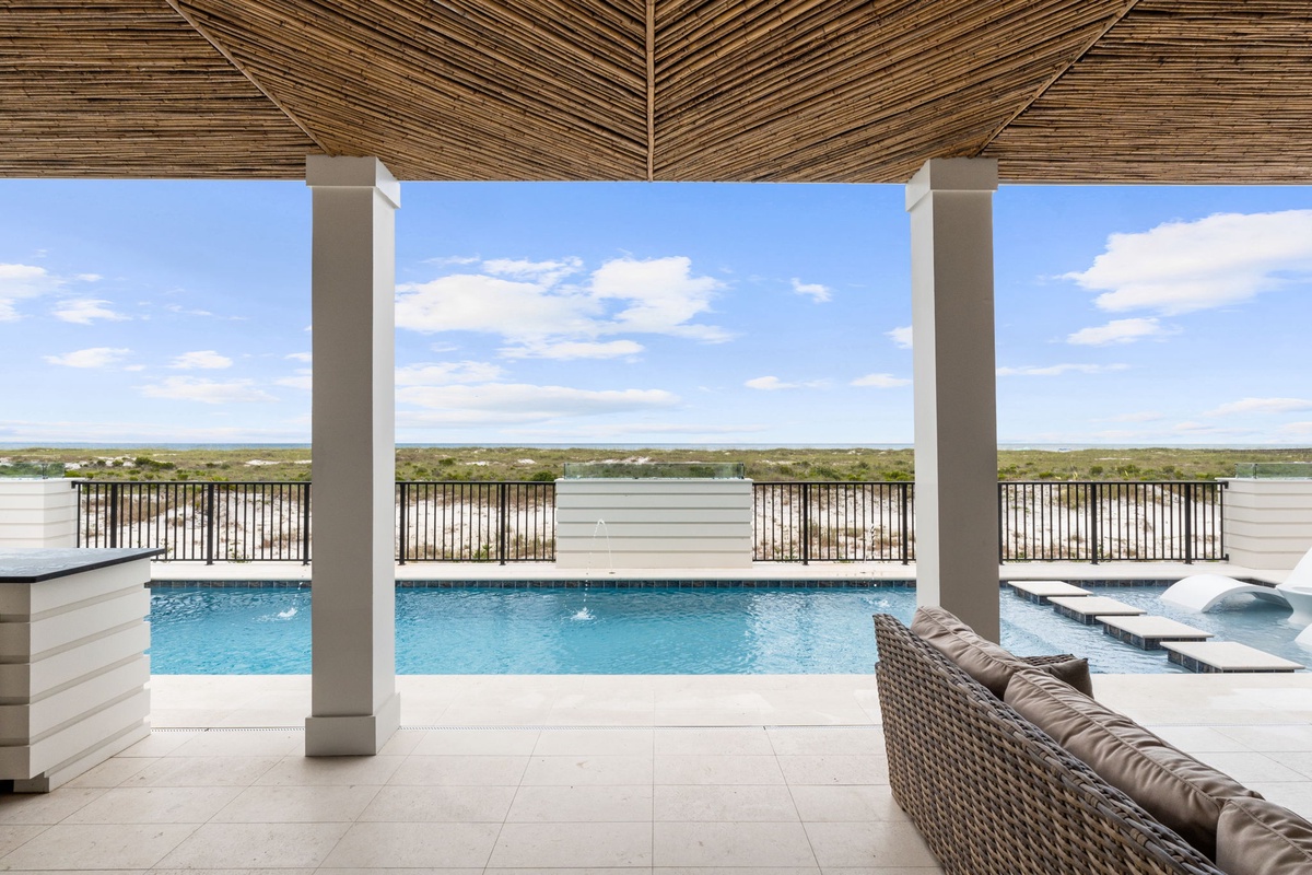 Relax in your private outdoor lounge under a stunning bamboo ceiling, where sparkling pool waters meet endless lake and landscape views—your perfect escape awaits.