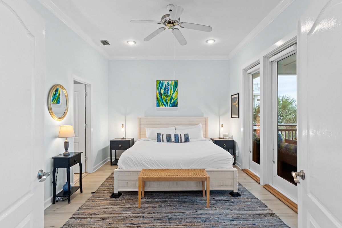 Your serene bedroom sanctuary awaits with crisp white linens and tropical artwork creating the perfect coastal retreat atmosphere.