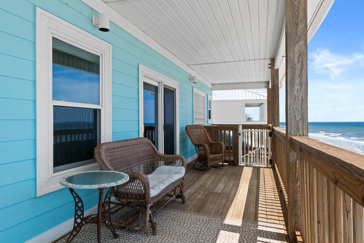 Step onto your private balcony and breathe in the coastal breeze—wicker seating and ocean waves create your perfect beachfront retreat.