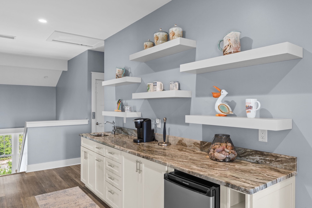 Your modern kitchen features granite countertops, floating shelves, and all the amenities needed for a comfortable stay.