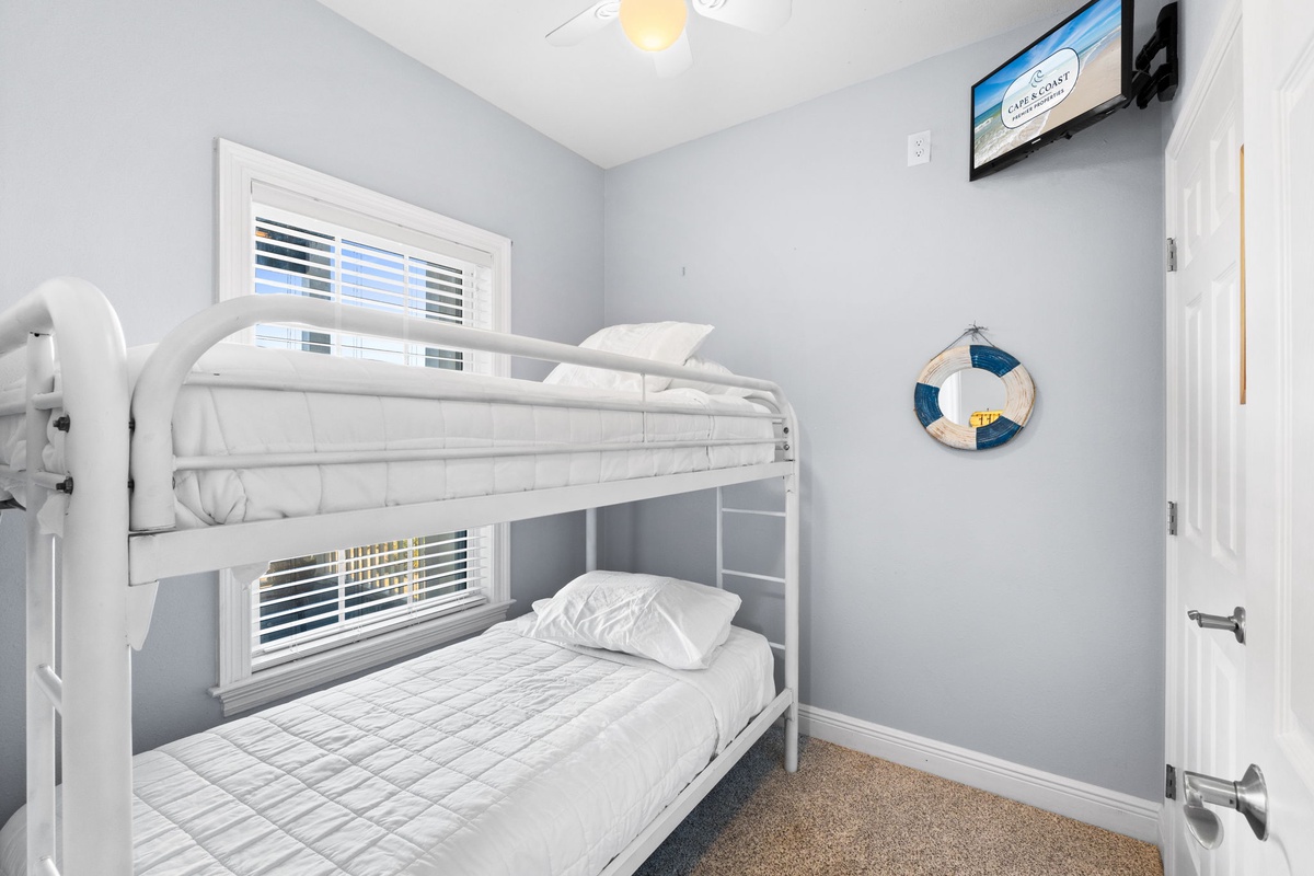 Your kids will love this cozy bunk bed retreat with nautical touches and entertainment right at their fingertips.