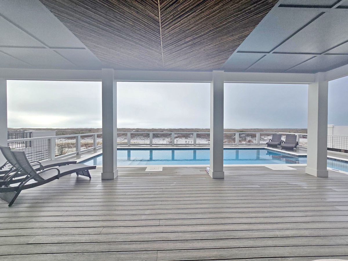 Unwind in your own covered pool pavilion, where striking wood-beamed ceilings frame endless views of the sparkling pool and horizon beyond.