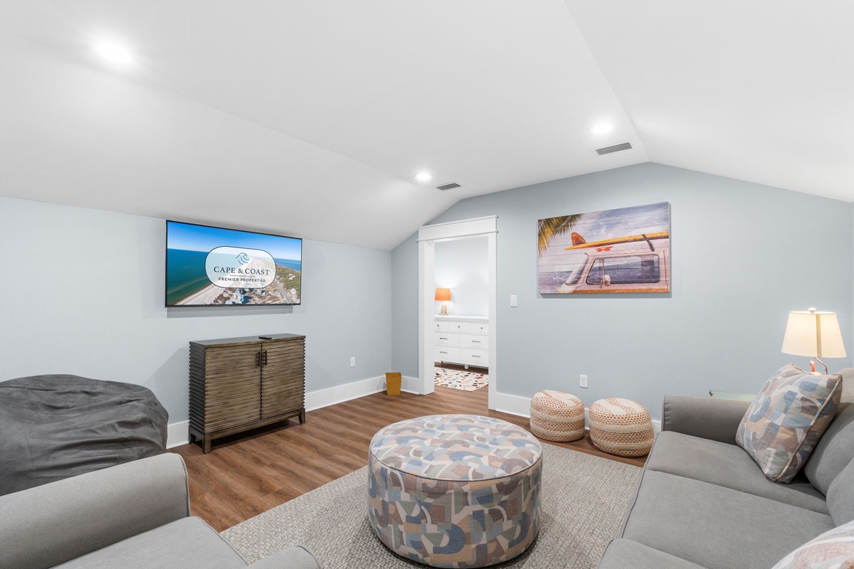 Kick back in your spacious upstairs living area—complete with vaulted ceilings, coastal vibes, and a large flatscreen for movie nights or lazy mornings.