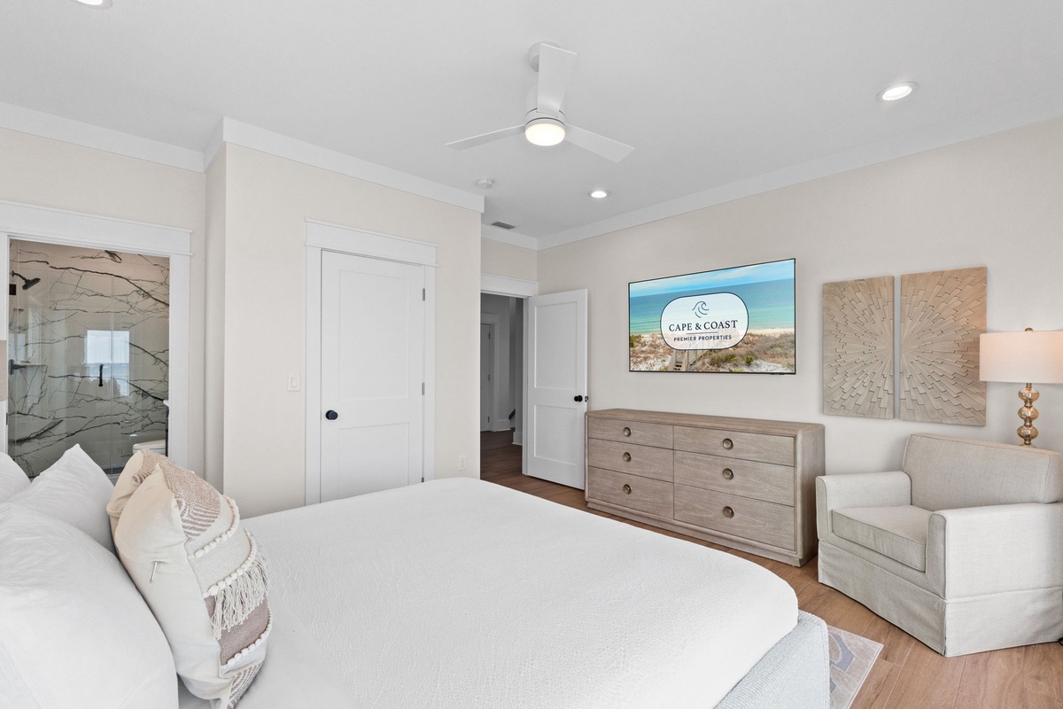 A calming coastal retreat awaits with soft linens, beachy decor, and your own cozy seating nook. Unwind beneath the ceiling fan's gentle breeze and wake to serene vibes.