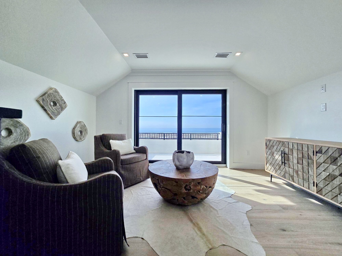 Relax in your sophisticated living space where modern comfort meets ocean views, featuring plush seating and stunning sea vistas from your private balcony.