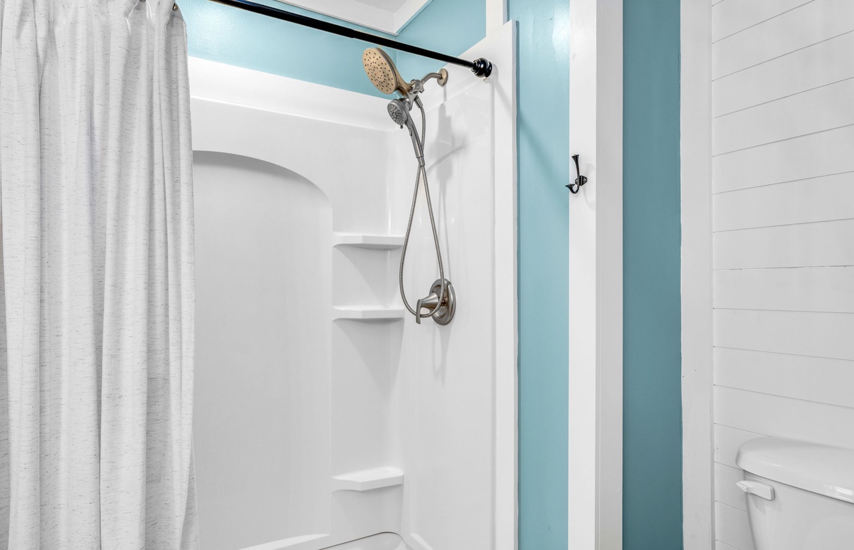 Step into your pristine bathroom featuring a spacious walk-in shower with modern fixtures and soothing blue accents for ultimate relaxation.