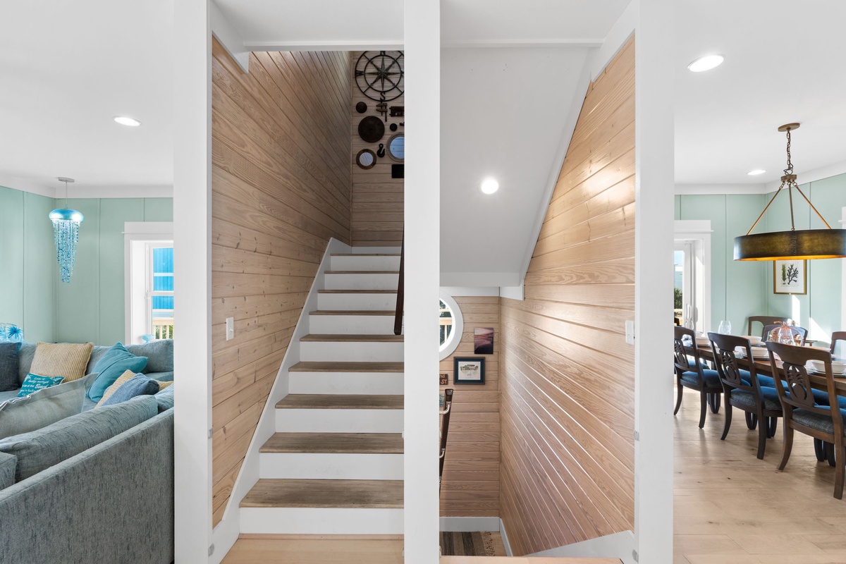 Step into your coastal-inspired retreat where warm wood accents and soothing sea-foam walls create the perfect backdrop for relaxation and memorable gatherings.