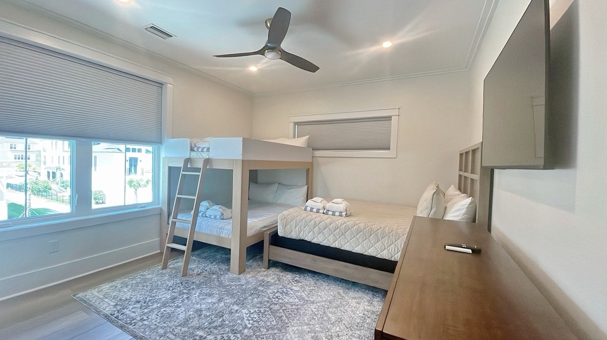 Your spacious bedroom features a bunk bed plus a comfy queen, perfect for families or friends. Natural light floods the room, and the ceiling fan keeps you cool.