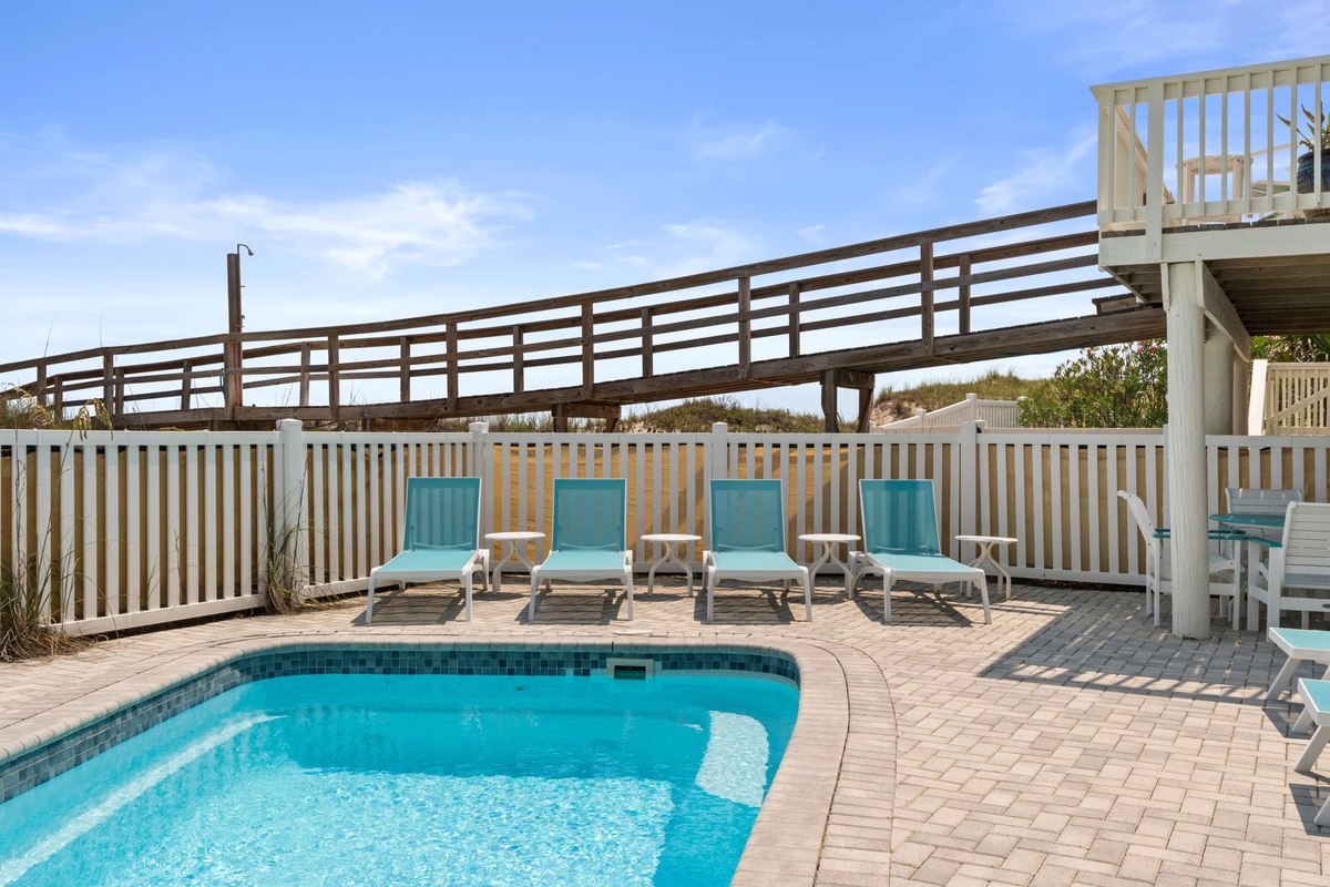 Your private pool awaits, surrounded by sunny lounge chairs and coastal breezes. Unwind poolside or take the boardwalk straight to the beach—it's just steps away.