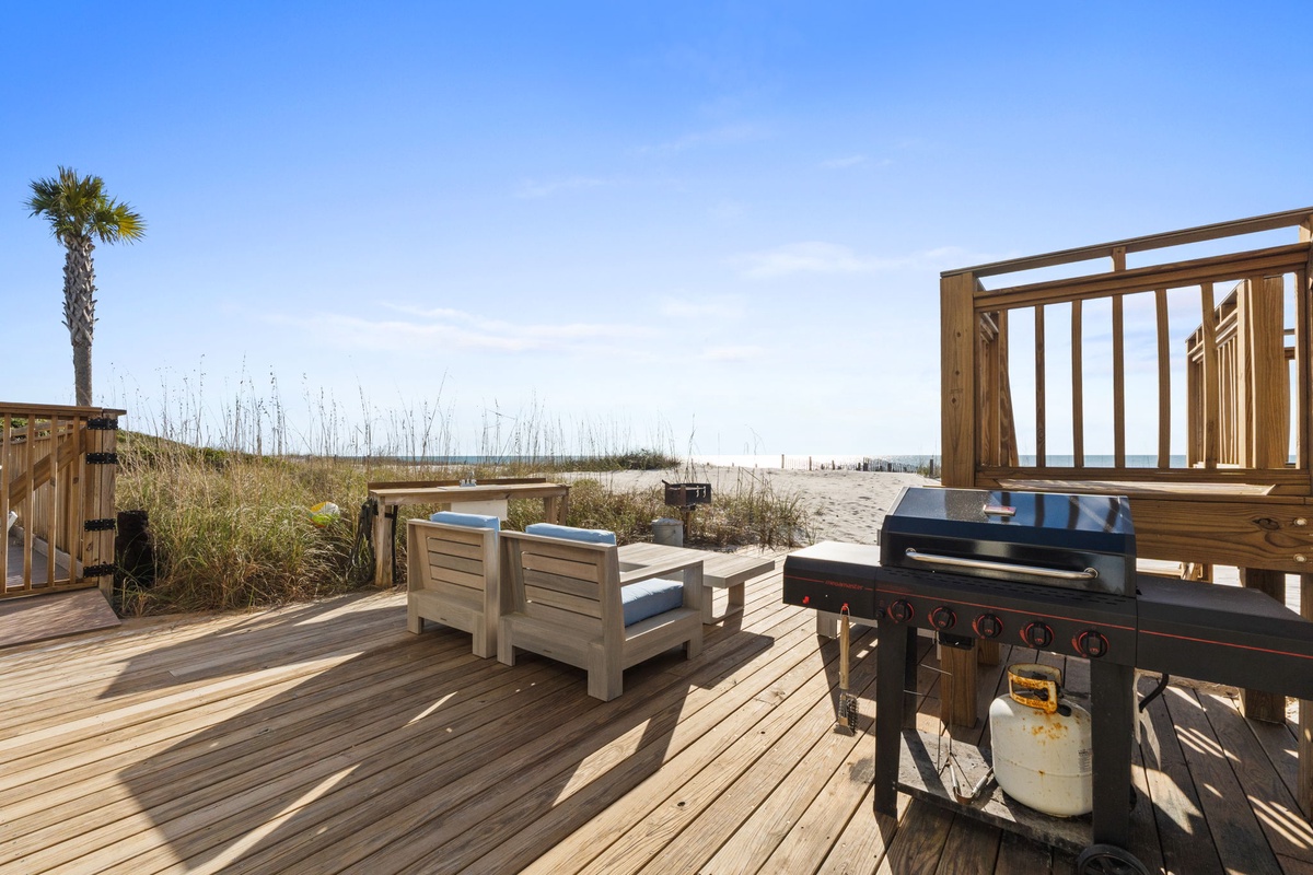 Beachfront deck with BBQ grill and seating just steps from pristine white sand.