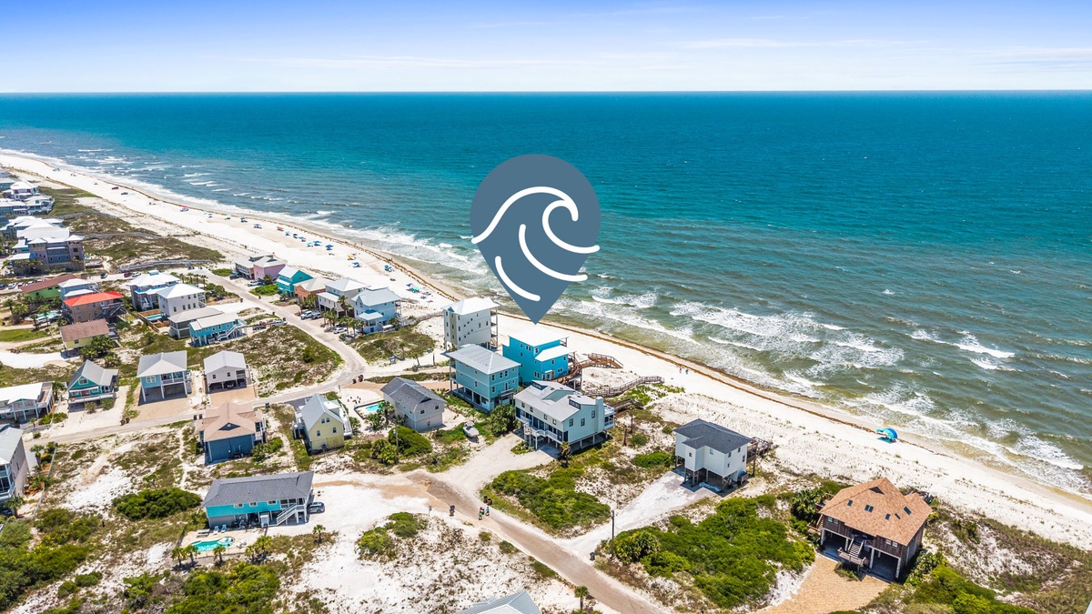 Aerial view of beachfront vacation homes nestled along pristine white sands and turquoise Gulf waters, showcasing the property's exclusive coastal location.