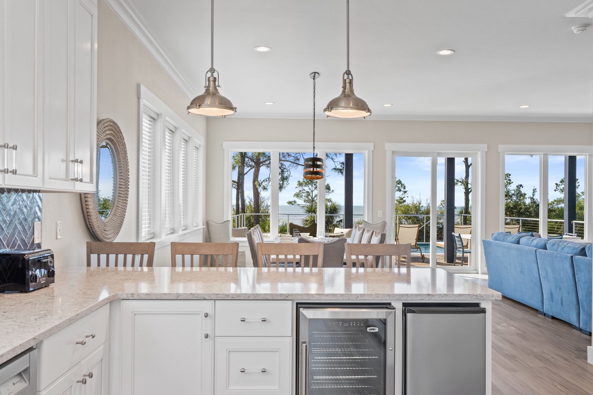 Your open-concept kitchen flows seamlessly into dining and living areas, with ocean views through floor-to-ceiling windows creating your perfect coastal retreat.