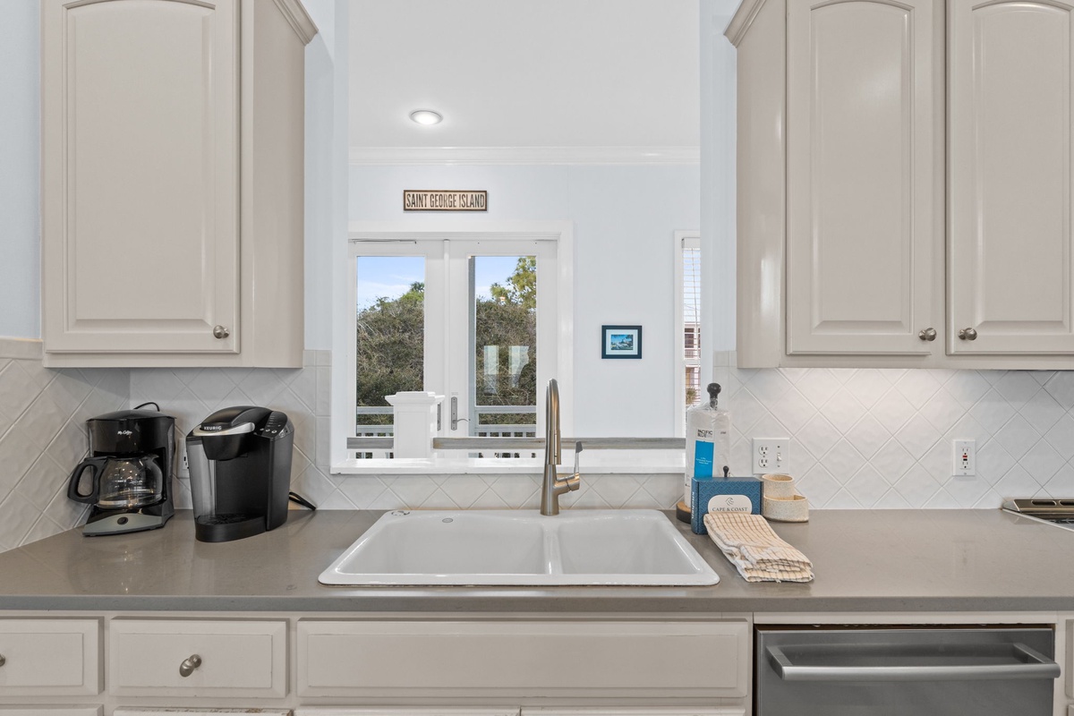 Your bright kitchen features modern appliances and a charming window view of lush greenery, perfect for morning coffee moments.