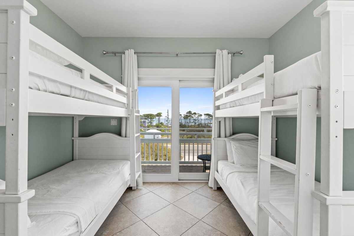 Your cozy bunk room features four comfortable beds and opens to a peaceful balcony overlooking scenic water views.