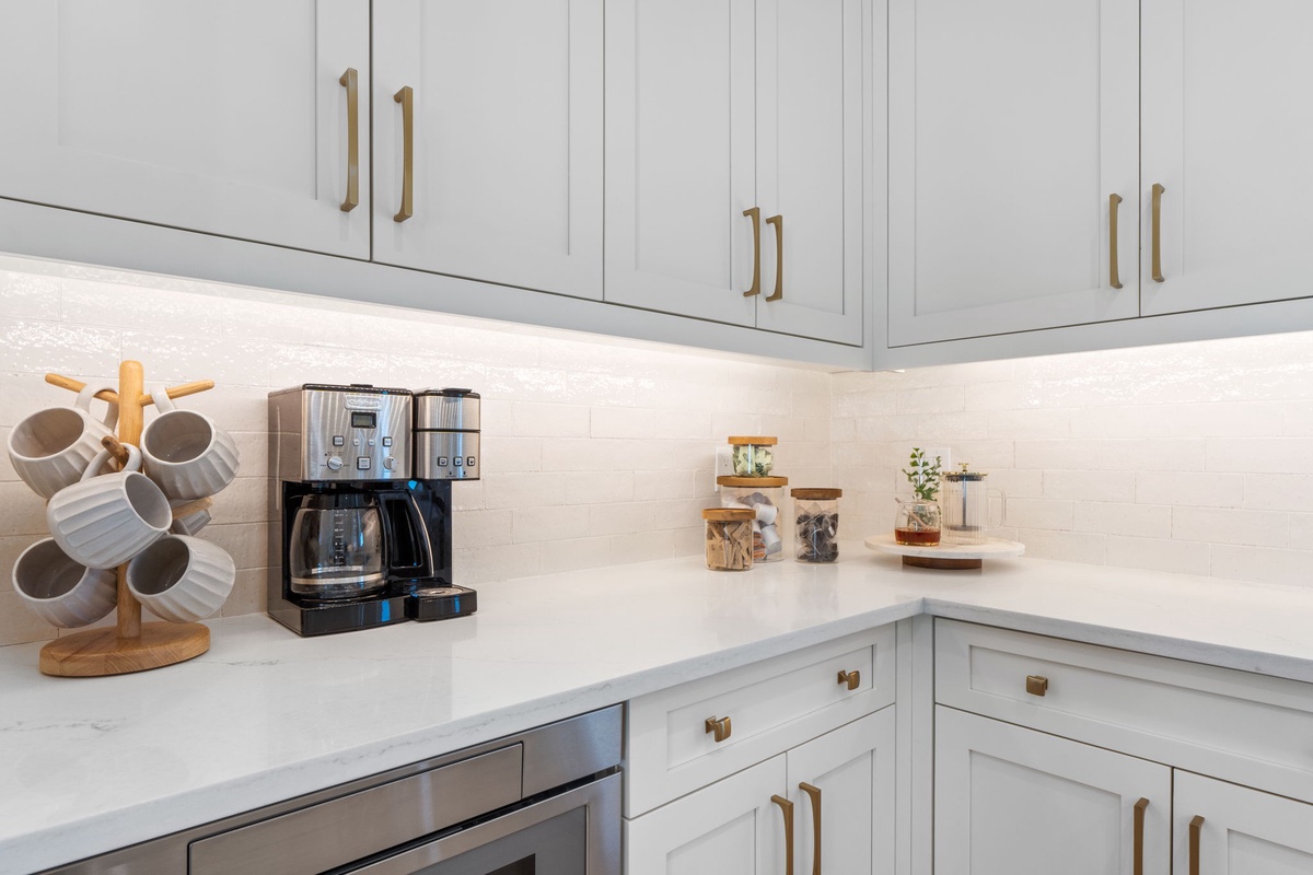 Your bright kitchen features elegant white cabinetry, marble countertops, and premium coffee facilities for perfect mornings.