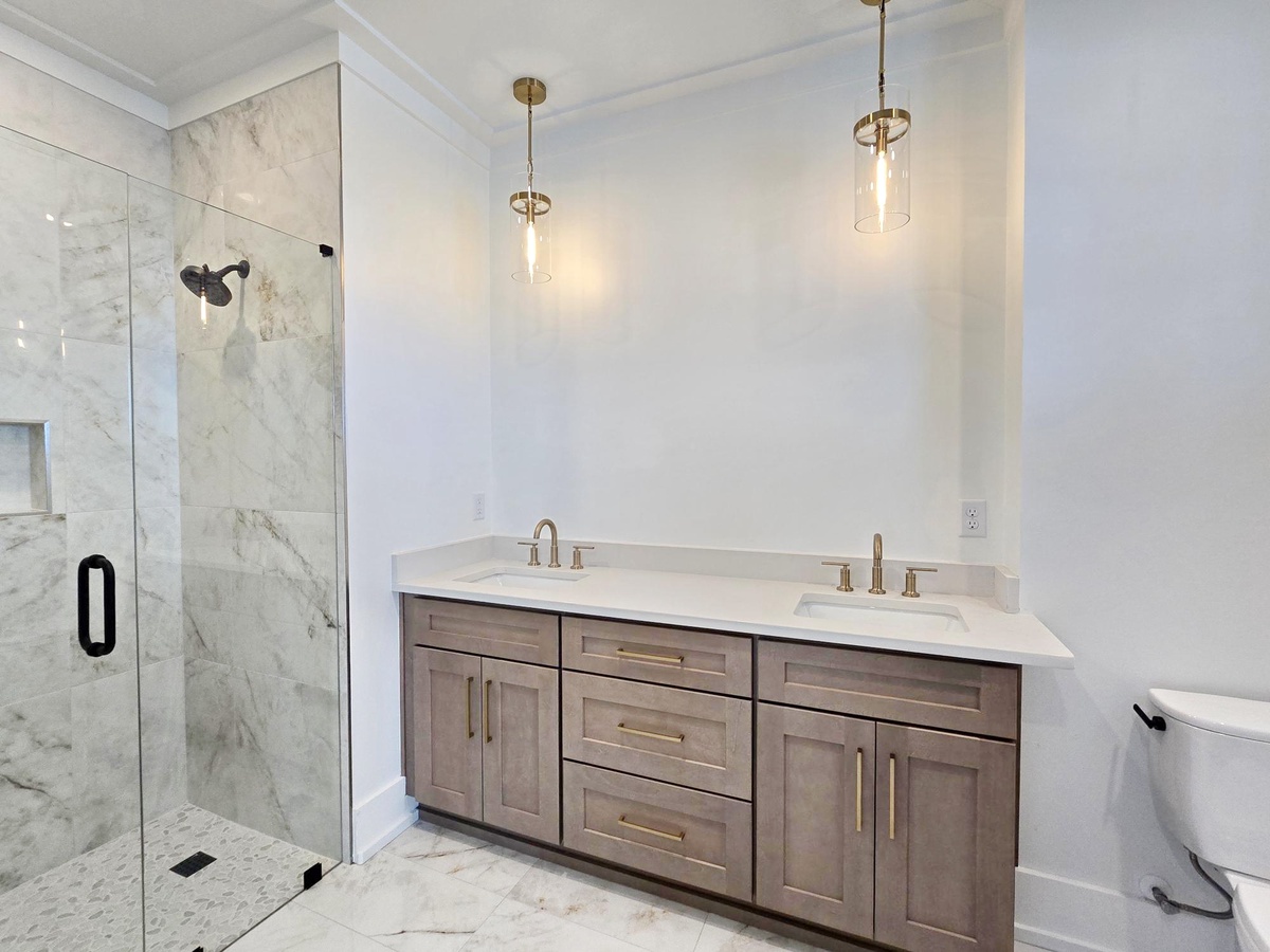 Your luxurious marble bathroom features elegant dual vanities and a stunning glass-enclosed shower for your ultimate relaxation.