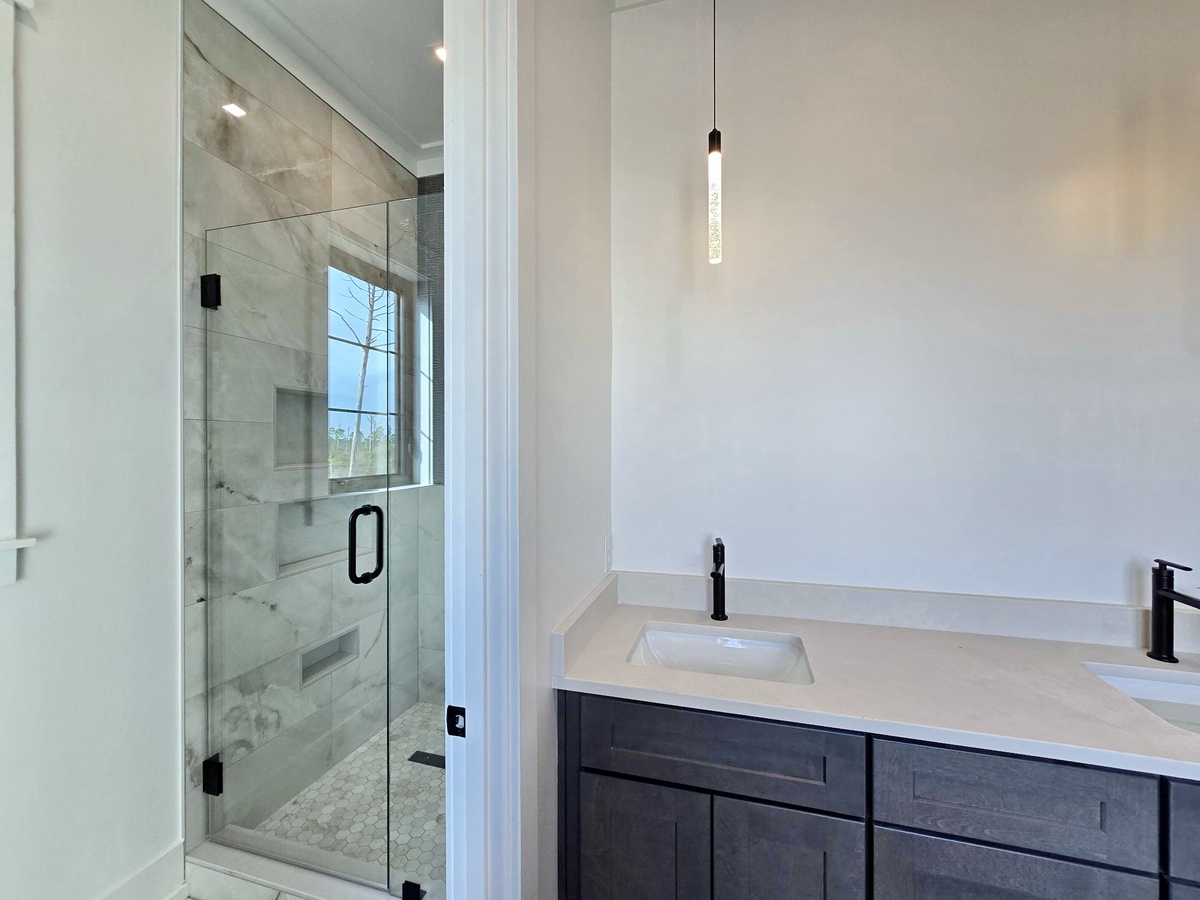Step into your spa-like bathroom sanctuary, complete with a marble-tiled shower and sleek vanity for your morning routine.